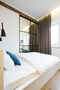 ein Schlafzimmer mit einem großen weißen Bett und einem großen Spiegel in der Unterkunft Apartment on Dauksos 18 in Kaunas