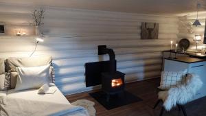 ein Zimmer mit Kamin, Bett und Stuhl in der Unterkunft Vildstugan in Björksjön