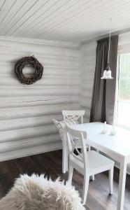 ein weißes Esszimmer mit einem weißen Tisch und Stühlen in der Unterkunft Vildstugan in Björksjön + 9 Fotos