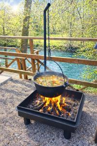 a pot of food cooking over a fire at Jugland-Private Riverside Retreat with Sauna & Hot Tub in Bajāri