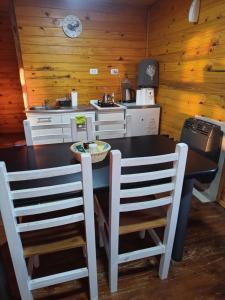 a kitchen with a table and chairs in a room at Cabañas Las Escondidas 3 in Chascomús