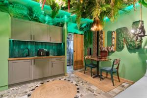 a kitchen with green walls and a table and chairs at YourSuite Studio Premium à Thème in Chaville