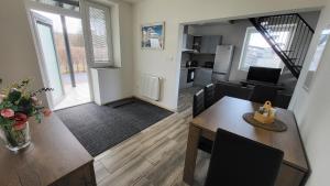 a living room with a dining table and a kitchen at Apartmán u kolejí A in Kašnice