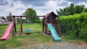 a playground with a slide and a swing at Apartmán u kolejí A in Kašnice