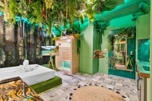a room with a bed and plants on the wall at YourSuite Studio Premium à Thème in Chaville