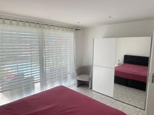 a bedroom with a red bed and a window at HOLIDAY Residence Sette Nani in San Nazzaro