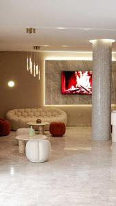 a living room with a couch and a tv at Hotel Donia Sfax in Sfax