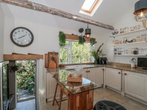a kitchen with a table and a clock on the wall at 7 The Cedars in Wotton-under-Edge