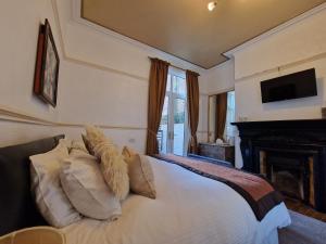 a bedroom with a bed with a fireplace and a television at Shearwater in Bridlington
