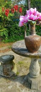 a vase filled with pink flowers on a stone table at B&B delle Arti in Crema +69 photos
