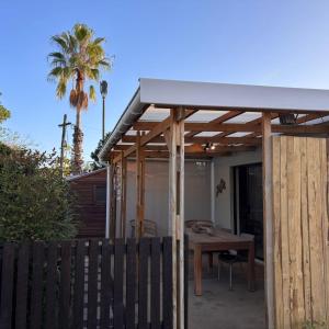 a wooden pergola with a wooden table in a backyard at Bonnie Doon Luxury Studio in Bunkers Hill