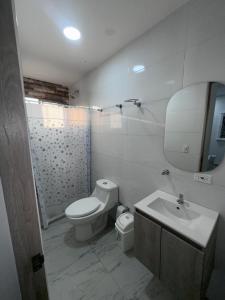 a white bathroom with a toilet and a sink at Bien ubicado 3 -habitaciones 3- Aires in Montería +9 photos
