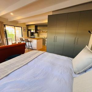 a bedroom with a large bed and a kitchen at Bonnie Doon Luxury Studio in Bunkers Hill