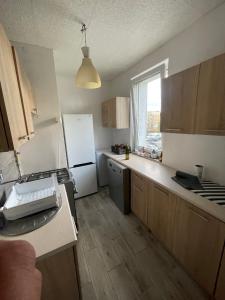 a kitchen with a white refrigerator and a window at U Damiana in Gdańsk