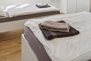 a pile of towels sitting on top of a bed at FENUS SGT01 moderne Ferienwohnung in Grabs +2 photos