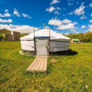 a yurt in a field with a wooden deck at Yurt near terelj in Nalayh