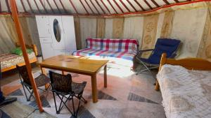 a room with a table and chairs and a bed at Yurt near terelj in Nalayh
