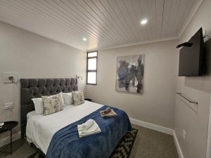 ein Schlafzimmer mit einem großen Bett und einem Fernseher in der Unterkunft Clanwilliam Accommodation in Clanwilliam