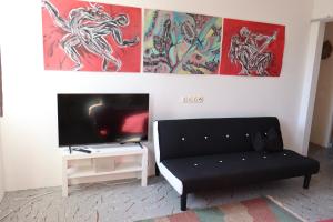 a living room with a couch and paintings on the wall at Holiday Home Desire in Kras