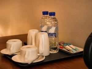 a tray with two bottles of water and two cups at Le Kree Downtown Hotel in Phnom Penh