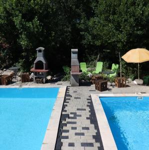 a swimming pool with a fireplace and a fire pit at Holiday Home Desire in Kras