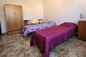 zwei Betten in einem Zimmer mit lila Bettwäsche in der Unterkunft Students Under 40 - Get 1 Night Free - Book Now in Palermo