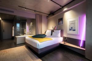 a bedroom with a king sized bed with purple lighting at mk2 Hotel Paradiso Nation in Paris