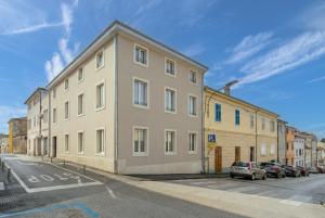 a large building with cars parked in a parking lot at Arriba Rooms in Poreč