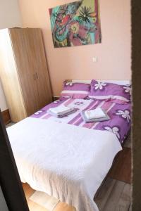 a bedroom with a bed with purple and white sheets at Holiday Home Desire in Kras +35 photos