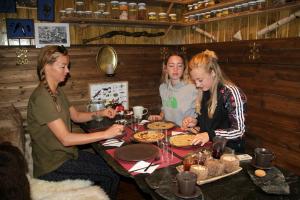 eine Gruppe von drei Mädchen, die an einem Tisch sitzen in der Unterkunft Hardanger Basecamp in Osa + 31 Fotos