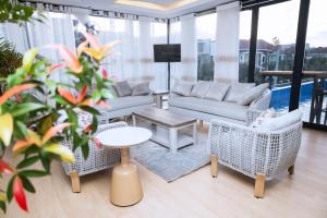 a living room with a couch and chairs and a table at Eza Hotel in Kigali