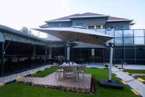 a person sitting at a table under an umbrella at Eza Hotel in Kigali