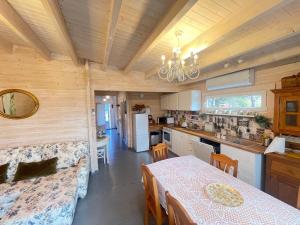 a kitchen and dining room with a table and chairs at Māja pie Ziedu laivas in Plieņciems