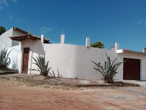 a white house with plants in front of it at Casa Bella barra do Jacuípe in Camaçari