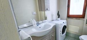 a bathroom with a sink and a washing machine at Speloncae Apartment in Sperlonga +14 photos