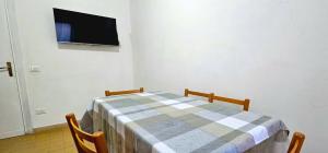 a table with two chairs and a tv on a wall at Speloncae Apartment in Sperlonga