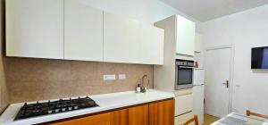 a kitchen with white cabinets and a stove top oven at Speloncae Apartment in Sperlonga