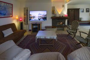 a living room with a couch and a table and a tv at Chez Lucie en Touraine in Montlouis-sur-Loire
