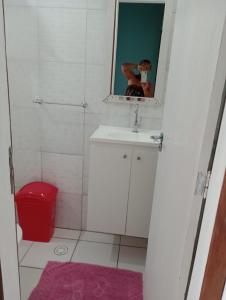 a person taking a picture of a bathroom with a mirror at Casa Bella barra do Jacuípe in Camaçari +17 photos