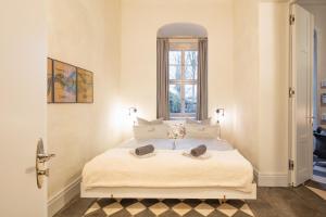 a bedroom with a large white bed with a window at Schloss Prossen in Bad Schandau