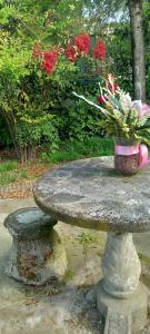 a stone table with a vase of flowers on it at B&B delle Arti in Crema