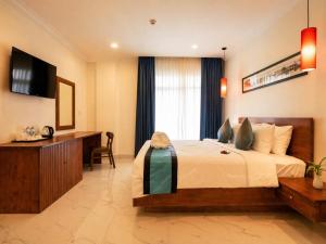 a hotel room with a bed and a desk at Le Kree Downtown Hotel in Phnom Penh