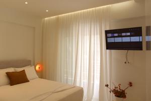 a bedroom with a bed and a television on a wall at SUMU Luxury Apartment in Lefkada