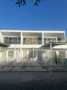 a white building with a fence in front of it at Bien ubicado 3 -habitaciones 3- Aires in Montería