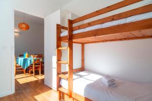 a bedroom with a bunk bed and a table at Lumineux logement vue sur le port in Audierne