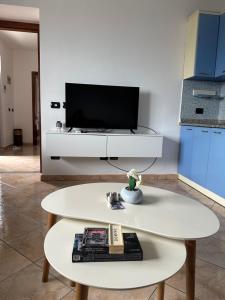 a living room with a white table and a tv at Emerald House Shiroke in Shkodër