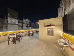 a patio with tables and chairs on a building at night at Evara Stays Backpackers Hostel in Kolkata