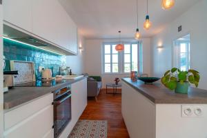 a kitchen with white cabinets and a counter top at Lumineux logement vue sur le port in Audierne