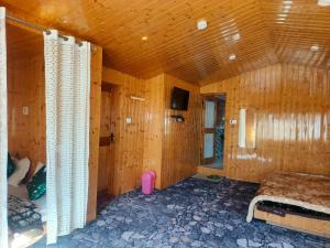 a bedroom with wooden walls and a bed in a room at Hotel Pahalgam Villas in Pahalgām