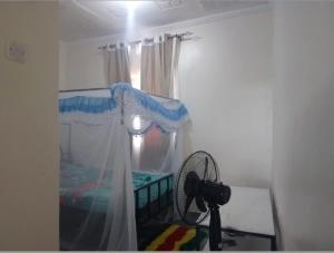 a bedroom with a bed and a window with a camera at Ibus Nawi Homes 2 in Lodwar